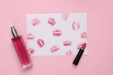 Dudak izi, beyaz kağıtta ruj izi ve mor pastel arka planda parfüm şişesi olan ruj izi. Sevgililer Günü, güzellik konsepti. Üst görünüm