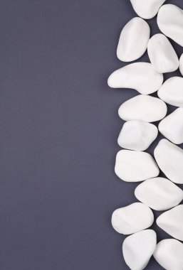 Gri arka planda beyaz çakıl taşları. Boşluğu kopyala
