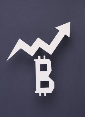 Btcoin sembolü kağıttan kesilmiş ve arka planda gri bir ok var. Finans kavramı