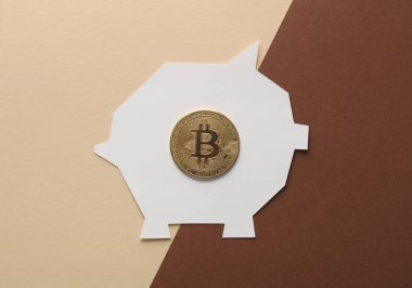 Kahverengi-bej arka planda bitcoin ile kağıt kesim domuz kumbarası