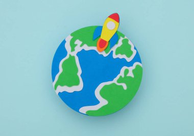 El yapımı, çocuk sanatı. Mavi arka planda roketi olan dünya gezegeni. Uzay keşfi