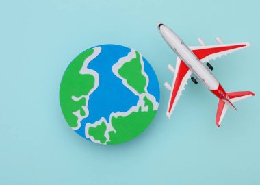 Mavi arka planda uçak olan dünya gezegeni..