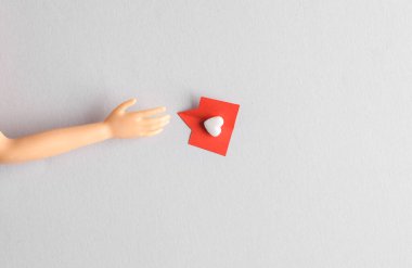 Kağıtları tutan oyuncak el gri arka plandaki gibi sosyal medyayı kesti. Yaratıcı asgari düzen