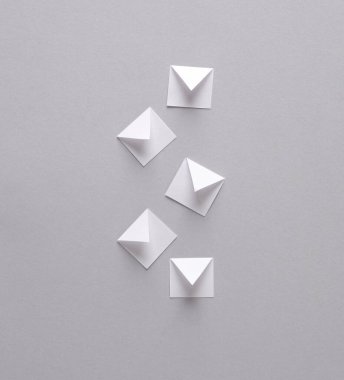 Kağıt kesme bildirimi mesaj zarfları gri arka planda. Yaratıcı minimalizm düzeni