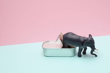 Pembe arka planda oyuncak fil olan teneke kutuyu aç. Yaratıcı yerleşim