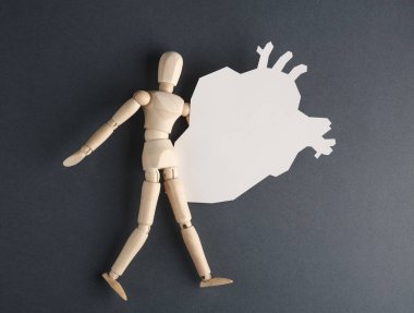 Gri arka planda kağıt anatomik kalbi olan tahta bir kukla. Sağlıklı kalp konsepti