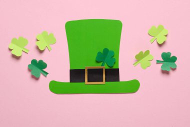 Aziz Patrick Günü 'nde. Pembe arka planda yonca yapraklı kağıt leprikon şapka. 17 Mart. El yapımı, kağıt sanatı. Düz yatıyordu. Üst görünüm