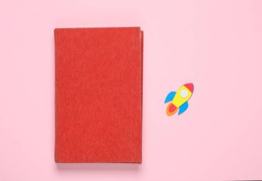 Pembe arka planda uzay mekiği olan kitap