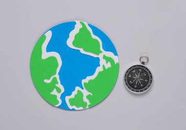 Gri arka planda pusulası olan Dünya gezegeni modeli