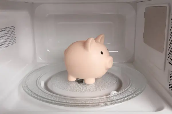 Piggy bank inside a microwave oven close-up