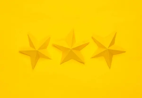 Three paper stars on yellow background. Service rating