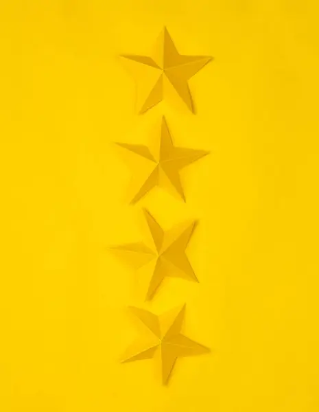 Four paper stars on yellow background. Service rating