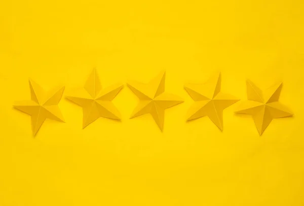 Five paper stars on yellow background. Service rating