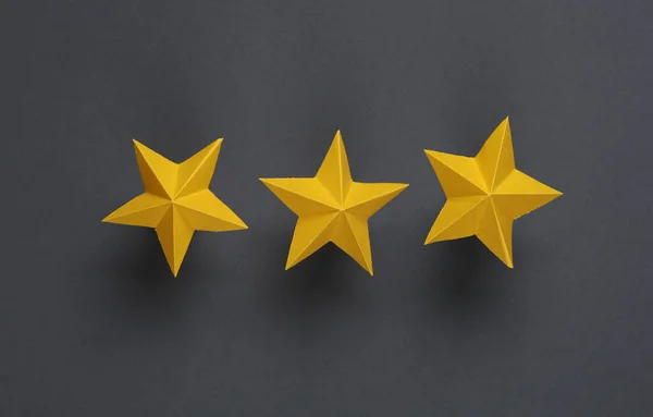 Three paper stars on gray background. Service rating