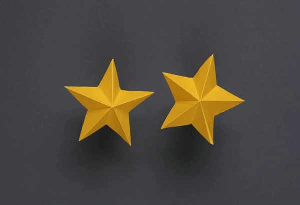 Two paper stars on gray background. Service rating