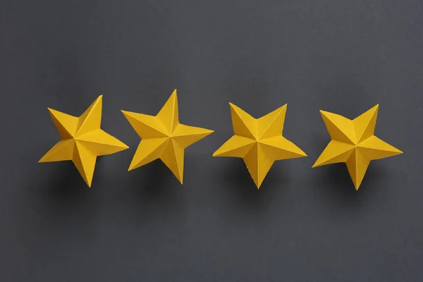 Four paper stars on gray background. Service rating