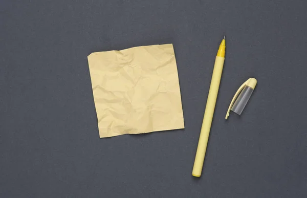 灰色の背景にペンが付いている粉砕された正方形のメモ紙 — ストック写真