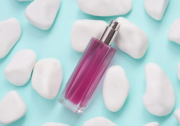 Parfymflaska Blå Bakgrund Med Småsten Skönhetsbegreppet — Stockfoto
