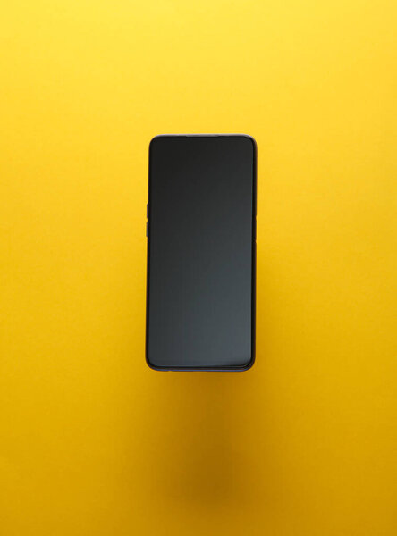 Smartphone on a yellow background with shadow