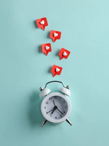 Alarm clock with Social media likes on blue background. Creative minimal layout