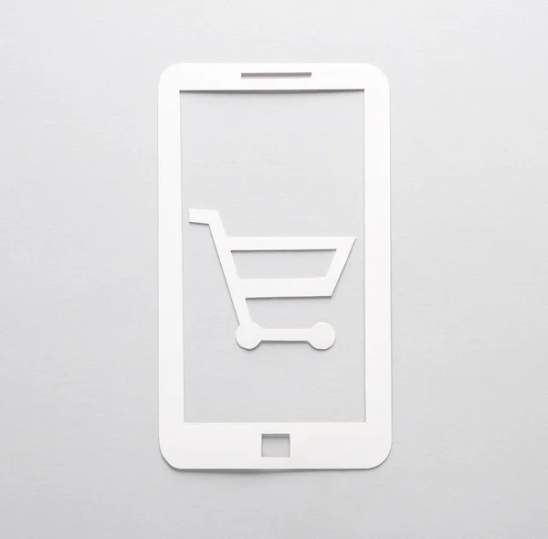 Een Papieren Smartphone Met Een Winkelwagentje Een Grijze Achtergrond Online — Stockfoto