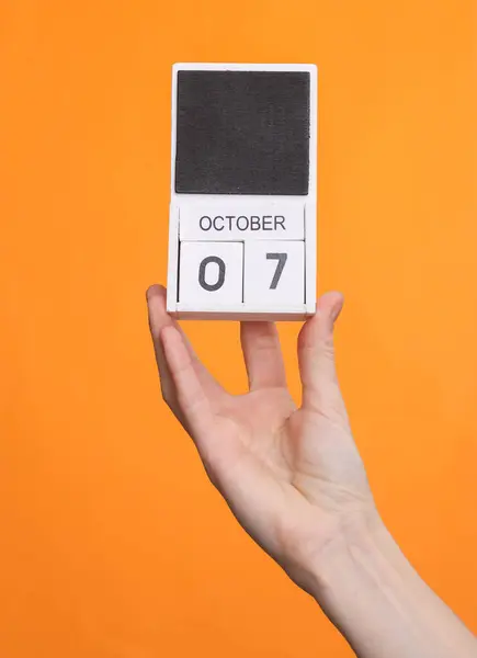 Treblokk Kalender Med Dato Oktober Kvinnelig Hånd Oransje Bakgrunn – stockfoto