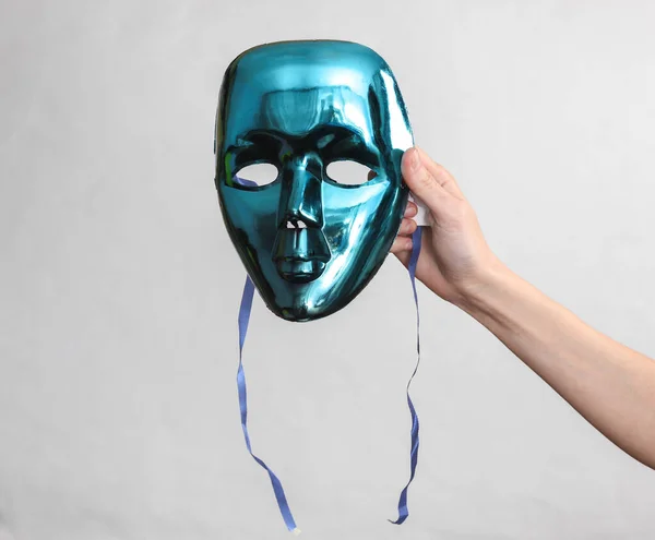グレーの背景に匿名のマスクを保持する女性の手 — ストック写真