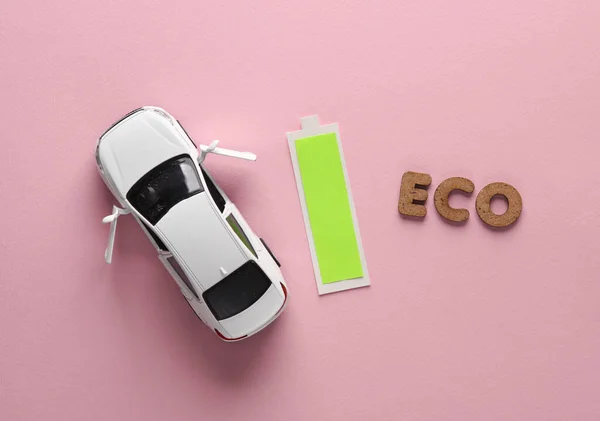 エレクトロカー 完全な充電レベル ピンクの背景にワードエコを備えた車とバッテリー トココンセプト — ストック写真