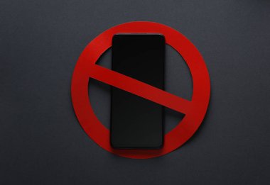 Koyu arkaplanda kırmızı yasak işareti olan akıllı telefon. Yasakla