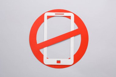 Kağıt, sarı arka planda kırmızı yasak işareti olan akıllı telefonu kesti. Yasakla