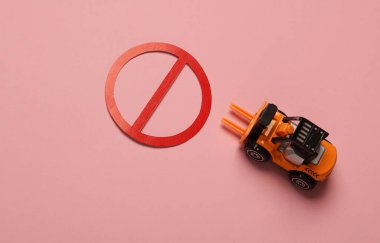Pembe arka planda yasaklı işareti olan bir forklift..