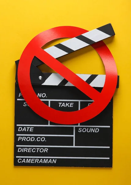 Movie clapperboard with prohibition sign on yellow background