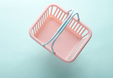 Mavi pastel arka planda plastik süpermarket sepeti
