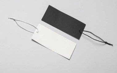 Beyaz ve siyah Blank giyim fiyat etiketleri veya etiketleri, gri arka planda dizgileri olan modeller. Satış, alışveriş konsepti.