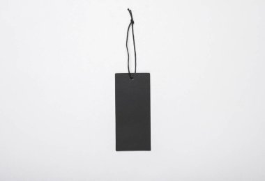 Siyah boş giyim etiketi ya da gri arka planda ipe sahip etiket modeli. Satış, alışveriş konsepti. Üst görünüm