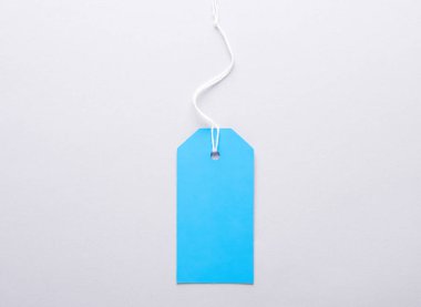 Mavi boş giyim etiketi ya da gri arka planda ipe sahip etiket modeli. Satış, alışveriş konsepti. Üst görünüm