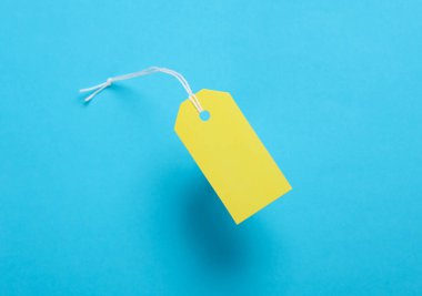 Mavi boş giyim etiketi ya da sarı arka planda ipe sahip etiket modeli. Satış, alışveriş konsepti. Üst görünüm