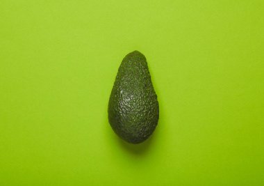 Yeşil arka planda olgun avokado. En az gıda konsepti
