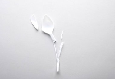 Gri arka planda kırık plastik kaşık. Plastik kirliliğini, geri dönüşümü, eko kavramını durdur