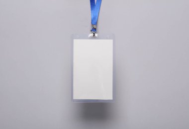 Boş beyaz kimlik kartı modeli ve gri arka planda mavi kuşak. Personel kimlik kartı. Metin ve tasarım için alan. Üst Manzara. Düz yatıyordu