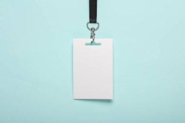 Mavi arka planda siyah kuşağı olan boş beyaz kimlik kartı modeli. Personel kimlik kartı. Metin ve tasarım için alan. Üst Manzara. Düz yatıyordu