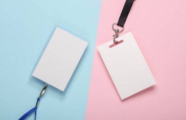 Boş beyaz kimlik kartı modelleri, pembe mavi arka planda kemerler. Personel kimlik etiketleri. Metin ve tasarım için alan. Üst Manzara. Düz yatıyordu