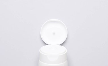 Gri arka planda açık krem tüp parçası. Üst görünüm