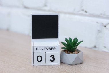 Tahta takvim, tarihi Kasım 03 ve masanın üzerine tuğla duvar arkası. Teslim tarihi, planlama, iş konsepti