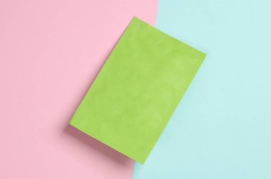 Mavi-pembe arka planda yeşil düz plastik ambalaj. Üst görünüm