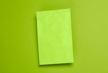 Yeşil arka planda yeşil düz plastik ambalaj. Üst görünüm