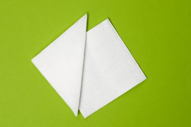 Yeşil arka planda beyaz kağıt peçeteler. Üst görünüm