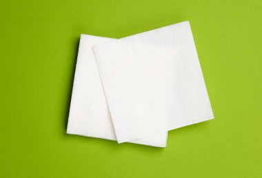 White paper napkins on a green background. Top view clipart