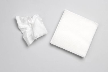 Gri arka planda beyaz kağıt peçeteler. Üst görünüm