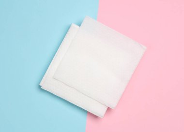 Pembe arka planda beyaz kağıt peçeteler. Üst görünüm